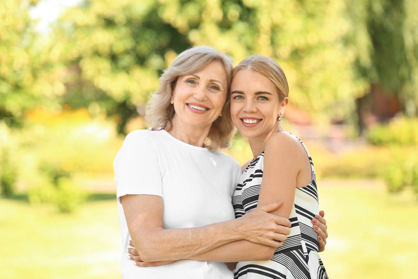 Portrait of beautiful mature woman with her daughter outdoors - Photo, Image