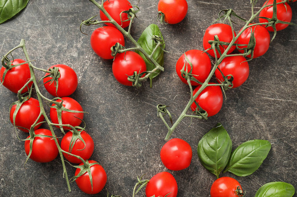 Fresh cherry tomatoes with basil on grey background - Фото, изображение