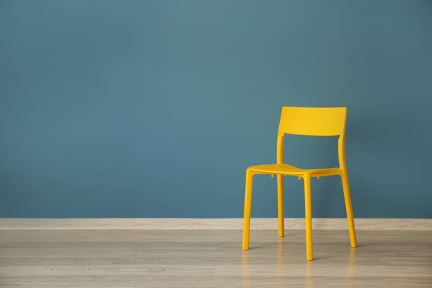 Yellow chair near color wall - Фото, зображення