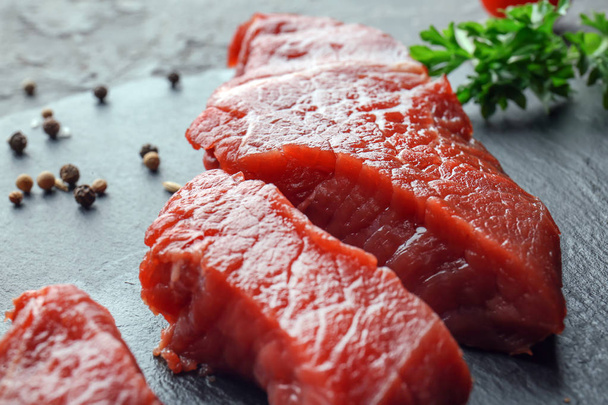 Raw meat on slate plate, closeup - Фото, изображение