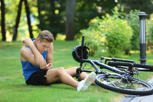 Joven caído de su bicicleta en el parque
 - Foto, Imagen