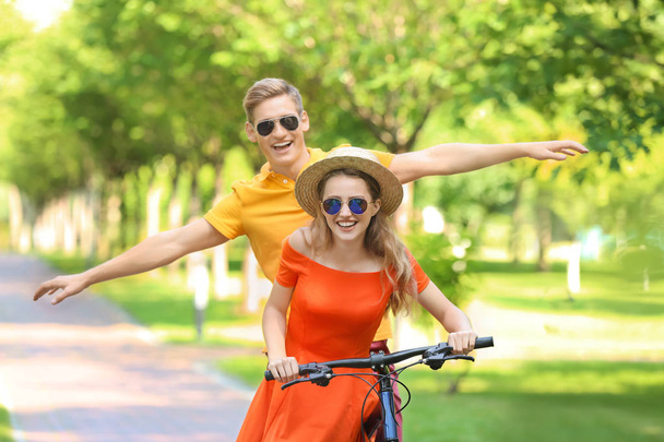 Young couple riding bicycle in park - Photo, Image
