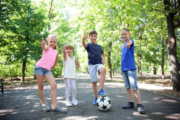 Χαριτωμένα παιδάκια με μπάλα ποδοσφαίρου στο πάρκο - Φωτογραφία, εικόνα