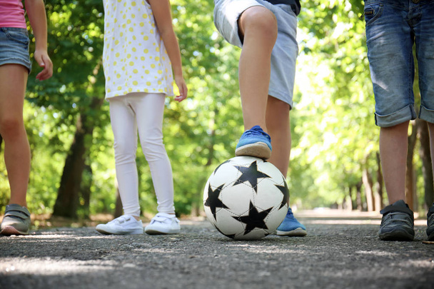 Leuke lieve kinderen met voetbal in park - Foto, afbeelding