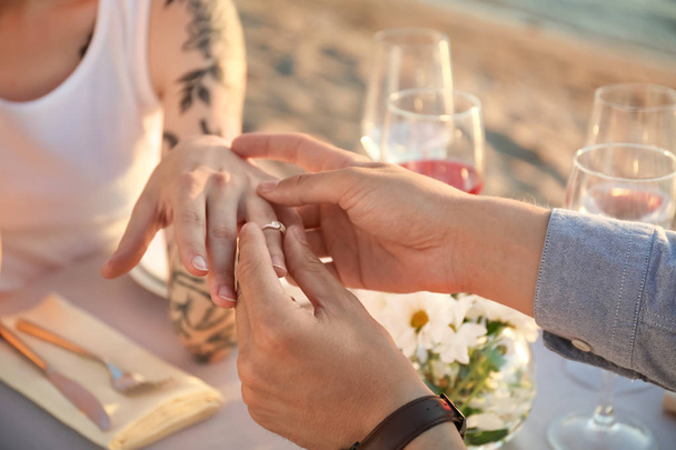 男は彼の最愛の屋外、クローズ アップの手に置く美しい婚約指輪 - 写真・画像