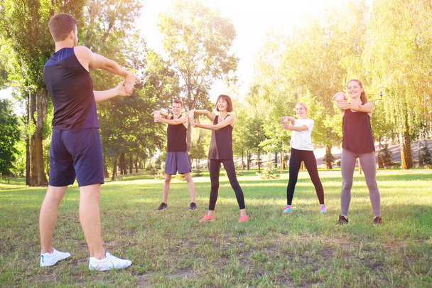 Group of sporty young people stretching outdoors - Photo, Image
