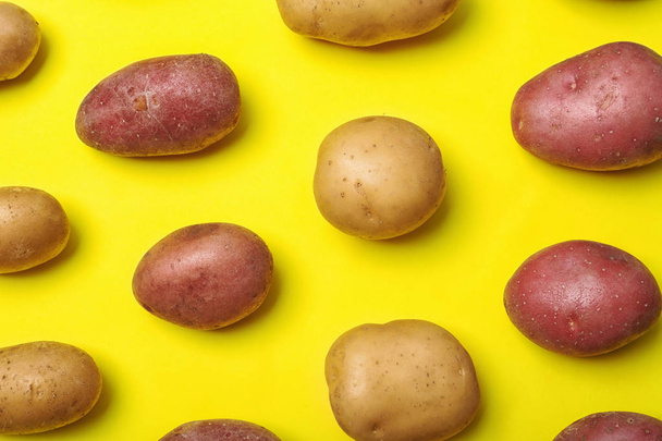Composição plana com batatas orgânicas frescas no fundo da cor
 - Foto, Imagem