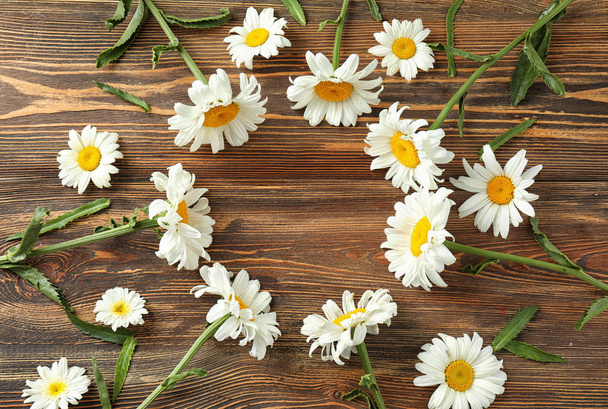 Frame made of beautiful chamomile flowers on wooden background - Zdjęcie, obraz