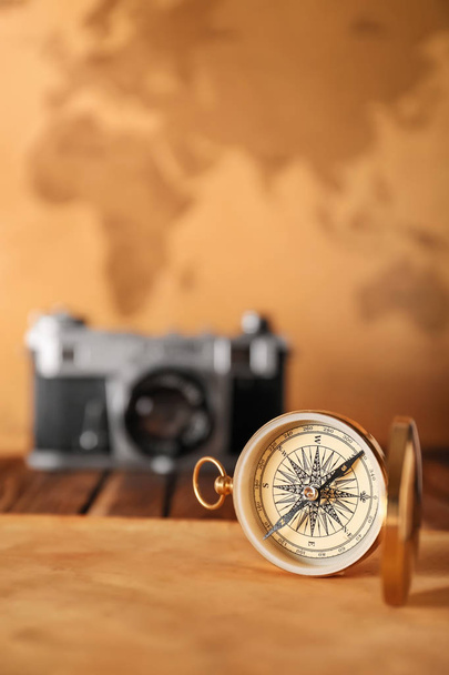 Vintage compass with sheet of paper on table against blurred background - Foto, Bild