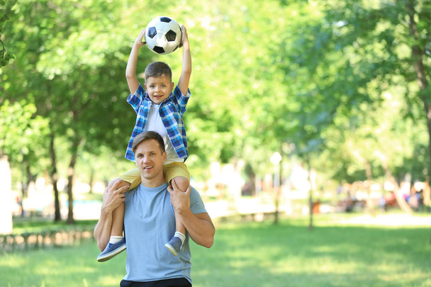 Mały chłopiec i jego tata z piłki nożnej w parku - Zdjęcie, obraz