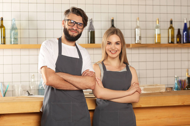 Female and male bartenders with crossed arms in bar - Valokuva, kuva