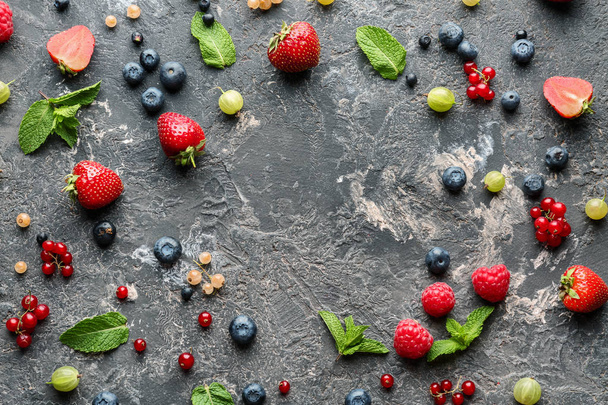 Delicious fresh berries on grey textured background - Photo, Image