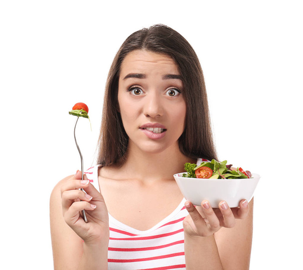 Νεαρή γυναίκα με υγιεινή σαλάτα λαχανικών σε λευκό φόντο - Φωτογραφία, εικόνα