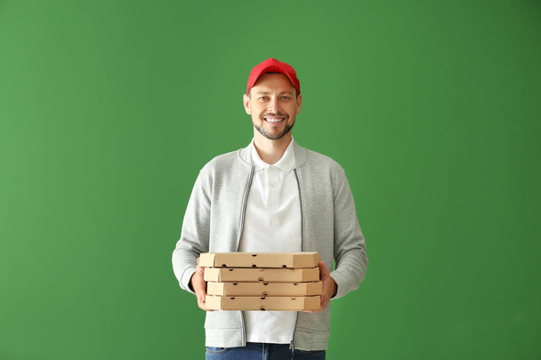 Człowiek z pudełek po pizzy na kolor tła. Dostawa żywności - Zdjęcie, obraz