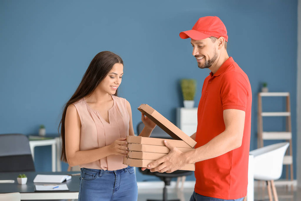 Человек, доставляющий пиццу клиенту в помещении
 - Фото, изображение
