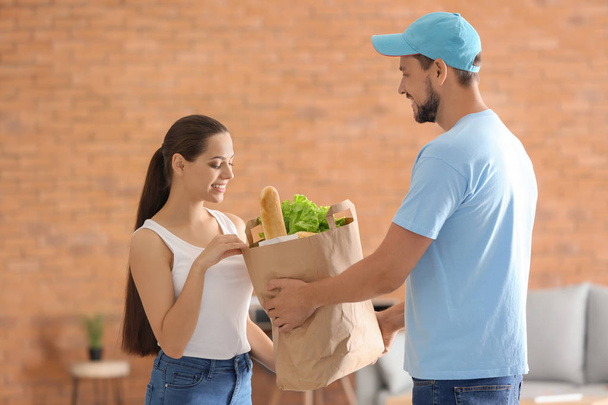 Man voedsel leveren aan klant binnenshuis - Foto, afbeelding