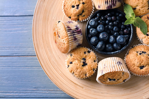 Muffin ai mirtilli saporiti con bacche fresche sul piatto
 - Foto, immagini