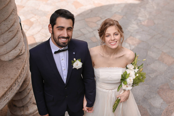 Happy newlyweds with beautiful wedding bouquet outdoors - Zdjęcie, obraz