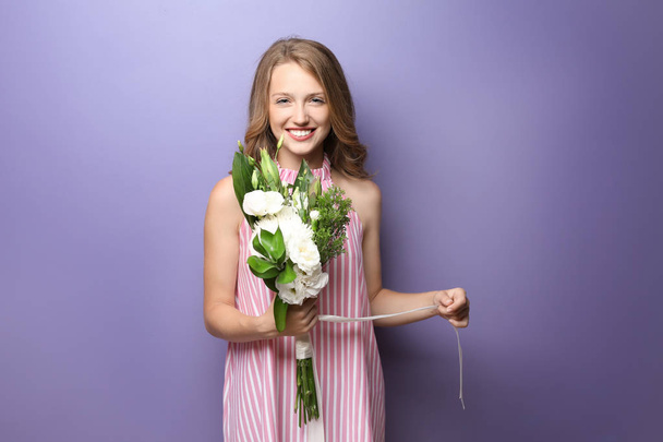 junge Frau mit schönen Blumen auf farbigem Hintergrund - Foto, Bild