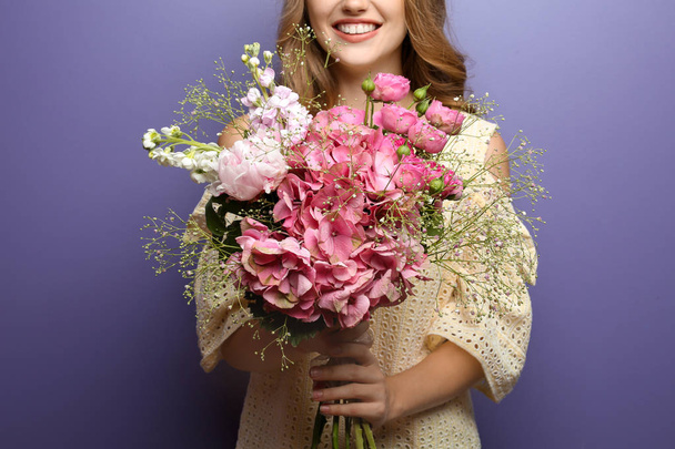 fiatal nő gyönyörű virágok a színes háttér - Fotó, kép