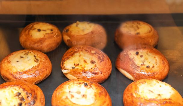 Φρέσκα ψωμάκια σε αρτοποιείο, δείτε μέσω του γυαλιού - Φωτογραφία, εικόνα