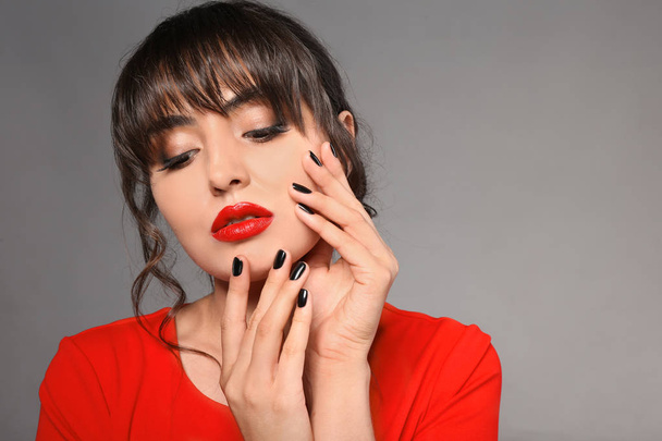 Beautiful young woman with professional manicure on grey background - Valokuva, kuva