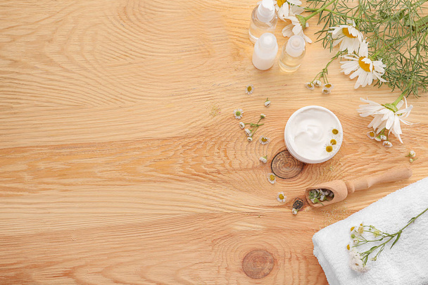 Composition with natural cosmetics and chamomile flowers on wooden background - Photo, Image