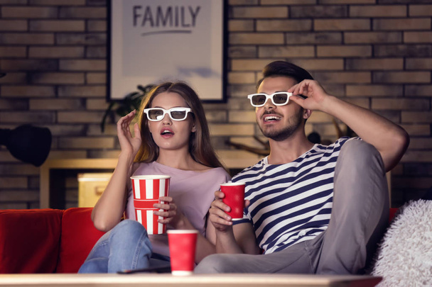 Jeune couple en 3d lunettes regarder film sur canapé la nuit
 - Photo, image