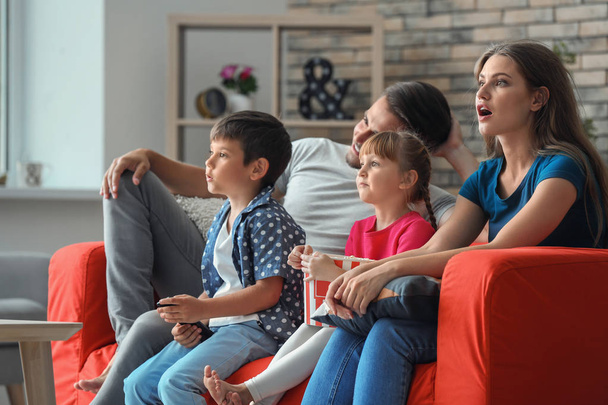 Family watching TV on sofa at home - Photo, Image