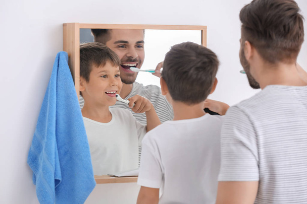 Little boy and his father brushing teeth in bathroom - Zdjęcie, obraz