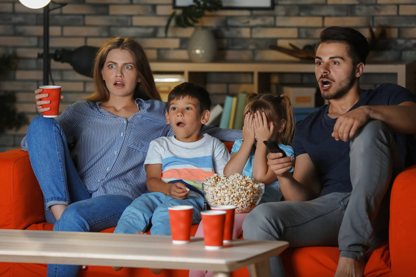Familie schaut abends auf dem Sofa fern - Foto, Bild