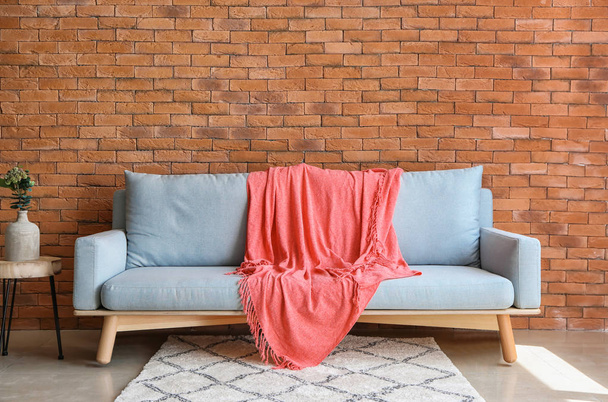 warmes rosa Plaid auf Sofa drinnen - Foto, Bild
