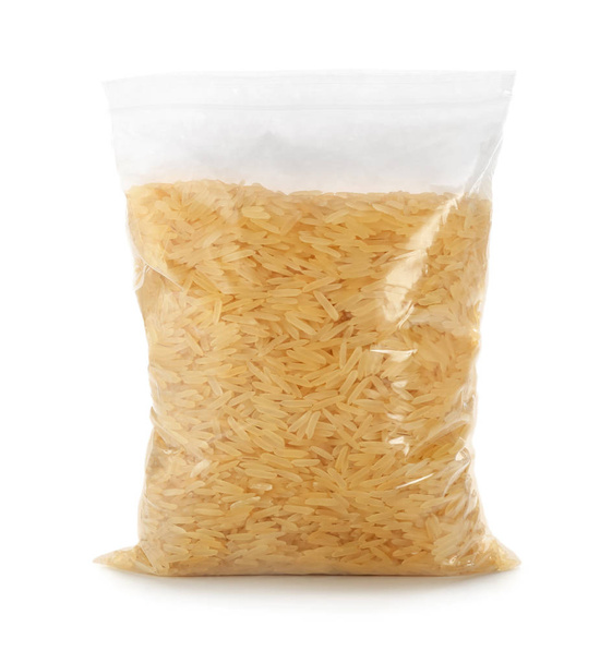 Reißverschlusstasche mit rohem braunem Reis auf weißem Hintergrund - Foto, Bild