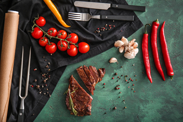 Smaczne mięso z grilla, warzywa, przyprawy i zioła na zielony stół - Zdjęcie, obraz