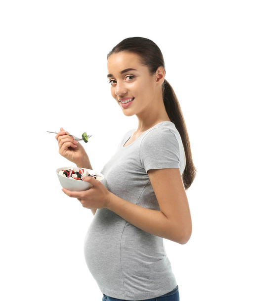 Young pregnant woman with healthy salad on white background - Φωτογραφία, εικόνα