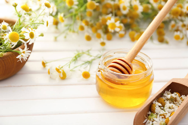 Sklenice medu s květy heřmánku na dřevěný stůl - Fotografie, Obrázek
