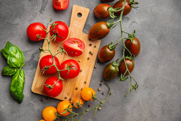 Ahşap tahta ve gri arka plan üzerinde farklı çeşit taze kiraz domates - Fotoğraf, Görsel