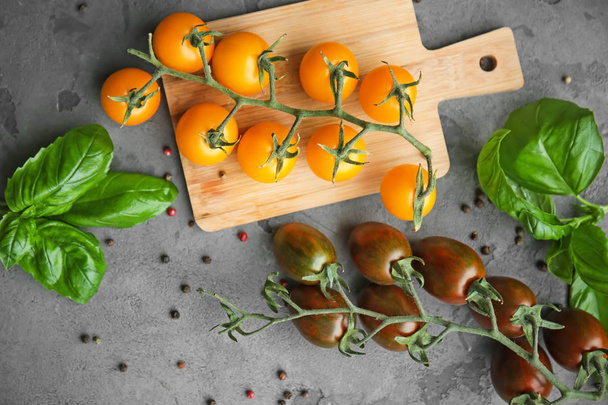 Ahşap tahta ve gri arka plan üzerinde farklı çeşit taze kiraz domates - Fotoğraf, Görsel