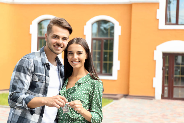 Mladý, šťastný pár s klíčem jejich nového domu venku - Fotografie, Obrázek