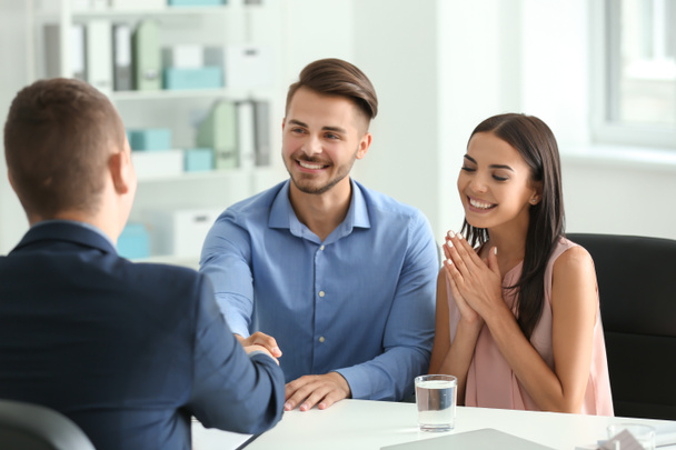 Young man shaking hands with estate agent in office - Photo, Image