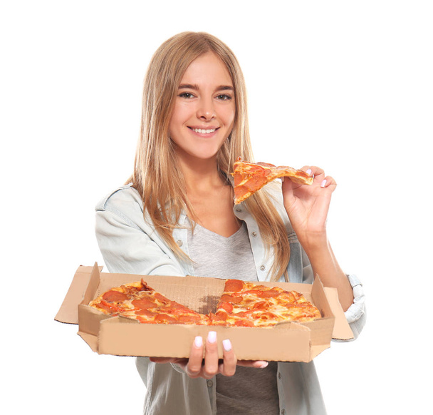 Νεαρή γυναίκα τρώει νόστιμη πίτσα σε λευκό φόντο - Φωτογραφία, εικόνα