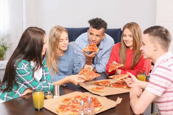 Young people having fun at party with delicious pizza indoors - Foto, Bild