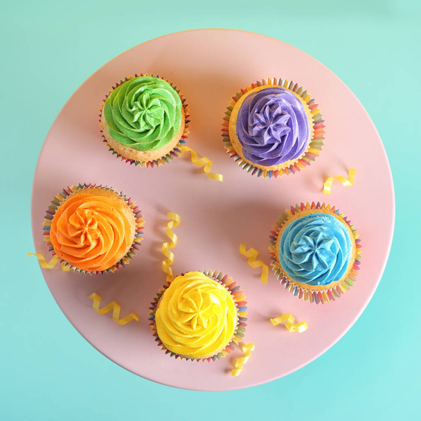 Stand with delicious birthday cupcakes on color background - Photo, Image
