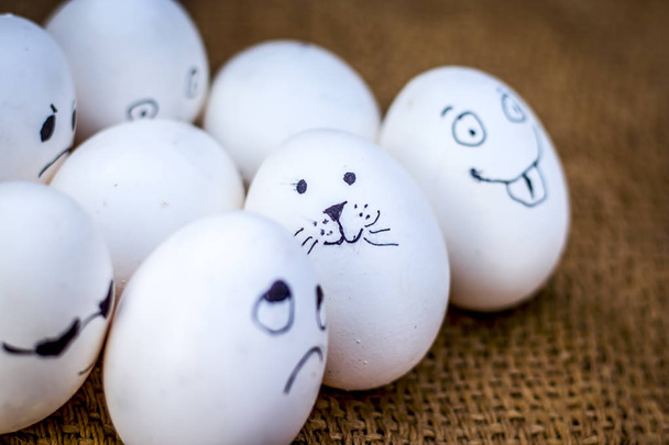 Close up view of eggs with funny faces drawn on them. - Foto, Bild