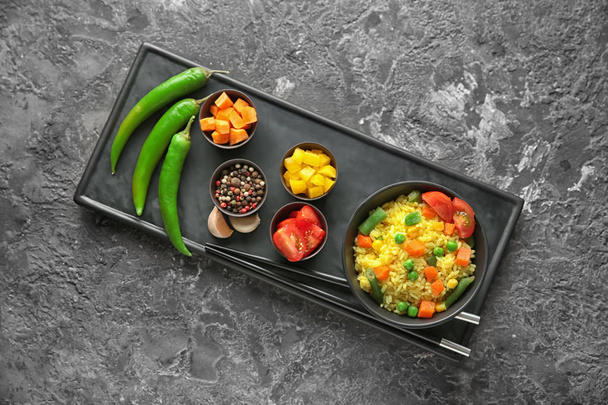 Bol avec riz bouilli savoureux et légumes et épices sur la table de grunge
 - Photo, image
