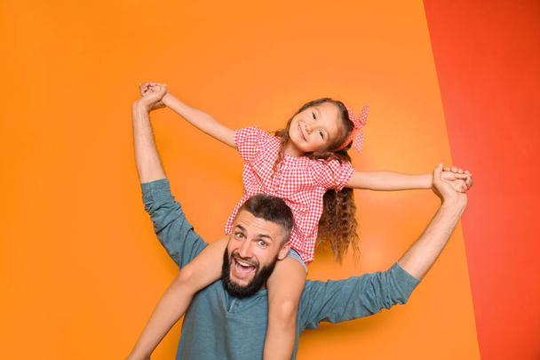 Baba ve küçük kızı renk arka plan üzerinde komik portresi - Fotoğraf, Görsel