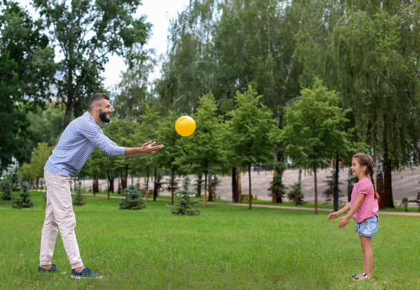 小さな女の子と彼女の父親は、屋外のボールで遊んで - 写真・画像