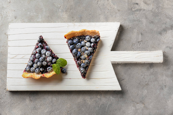 Deska z kawałkami pyszny blueberry pie na stole - Zdjęcie, obraz
