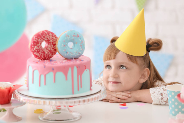 Nettes kleines Mädchen mit leckerem Geburtstagskuchen auf Party - Foto, Bild