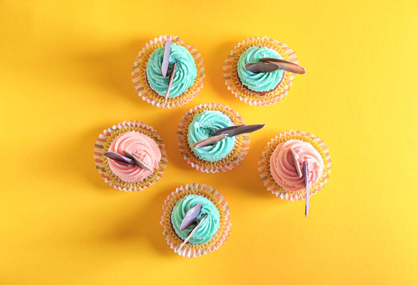 Вкусные праздничные кексы на цветном фоне
 - Фото, изображение